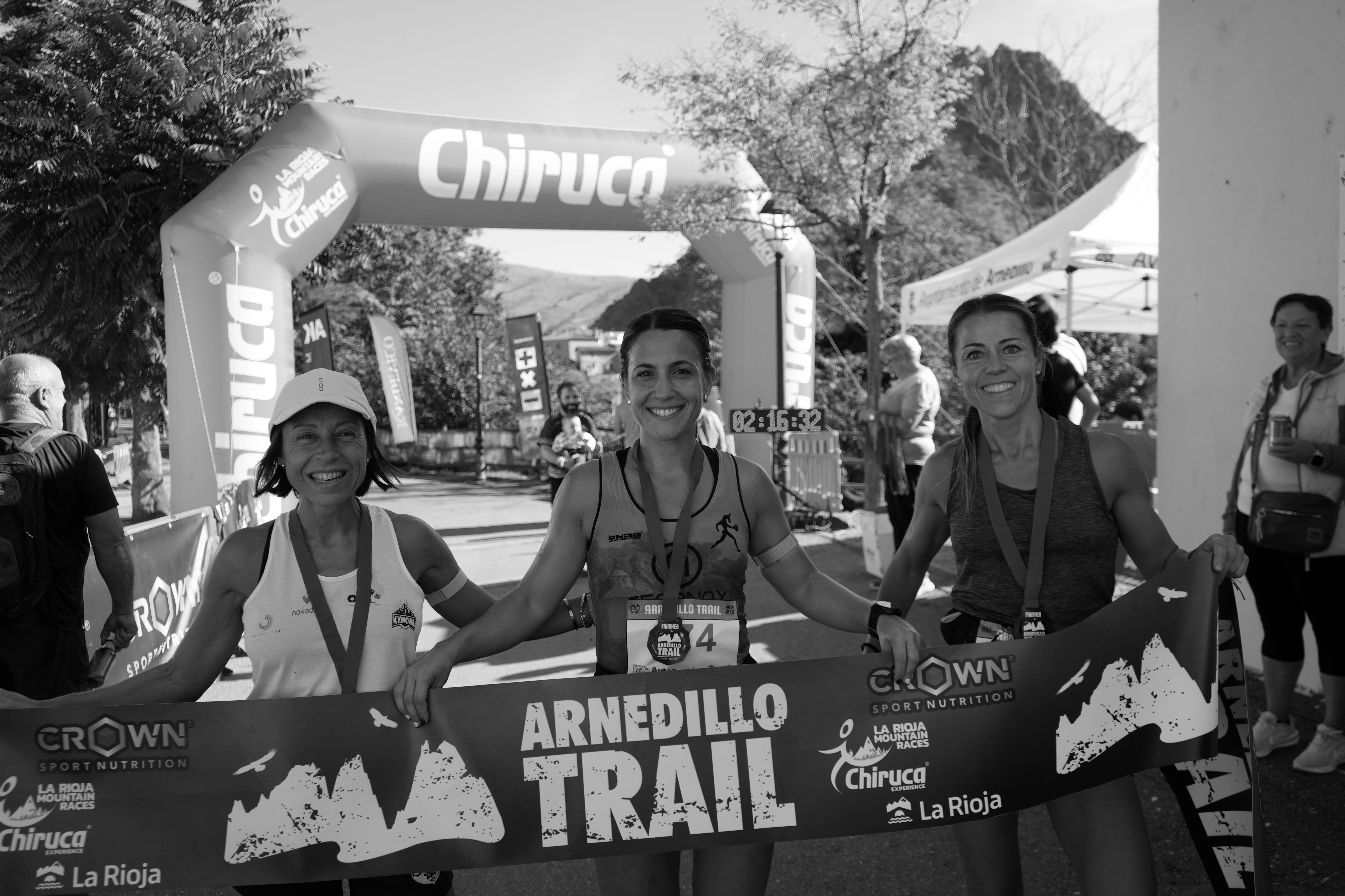 Tres corredoras posando en meta con el banner del Arnedillo Trail